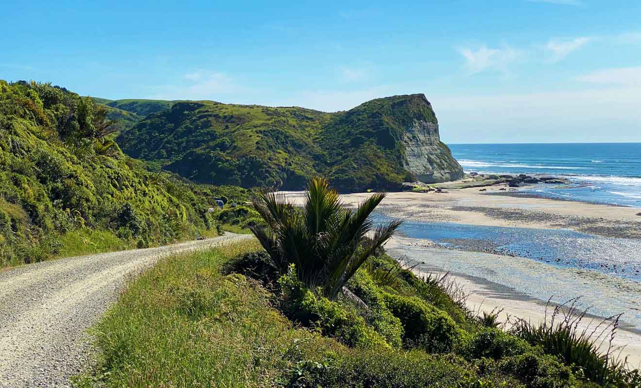 La route rejoint des plages désertes bordées de falaises.