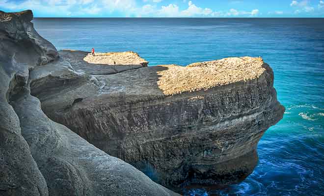 Les rochers qui s'avancent dans la mer sont peu à peu rongés par l'érosion.