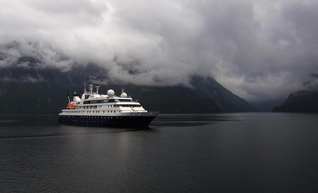 Des navires de croisières sillonnent les eaux du fiord en compagnie de quelques voiliers.