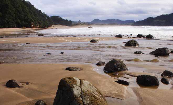 La source remonte à la surface à partir d'une faille située près des rochers de la plage.