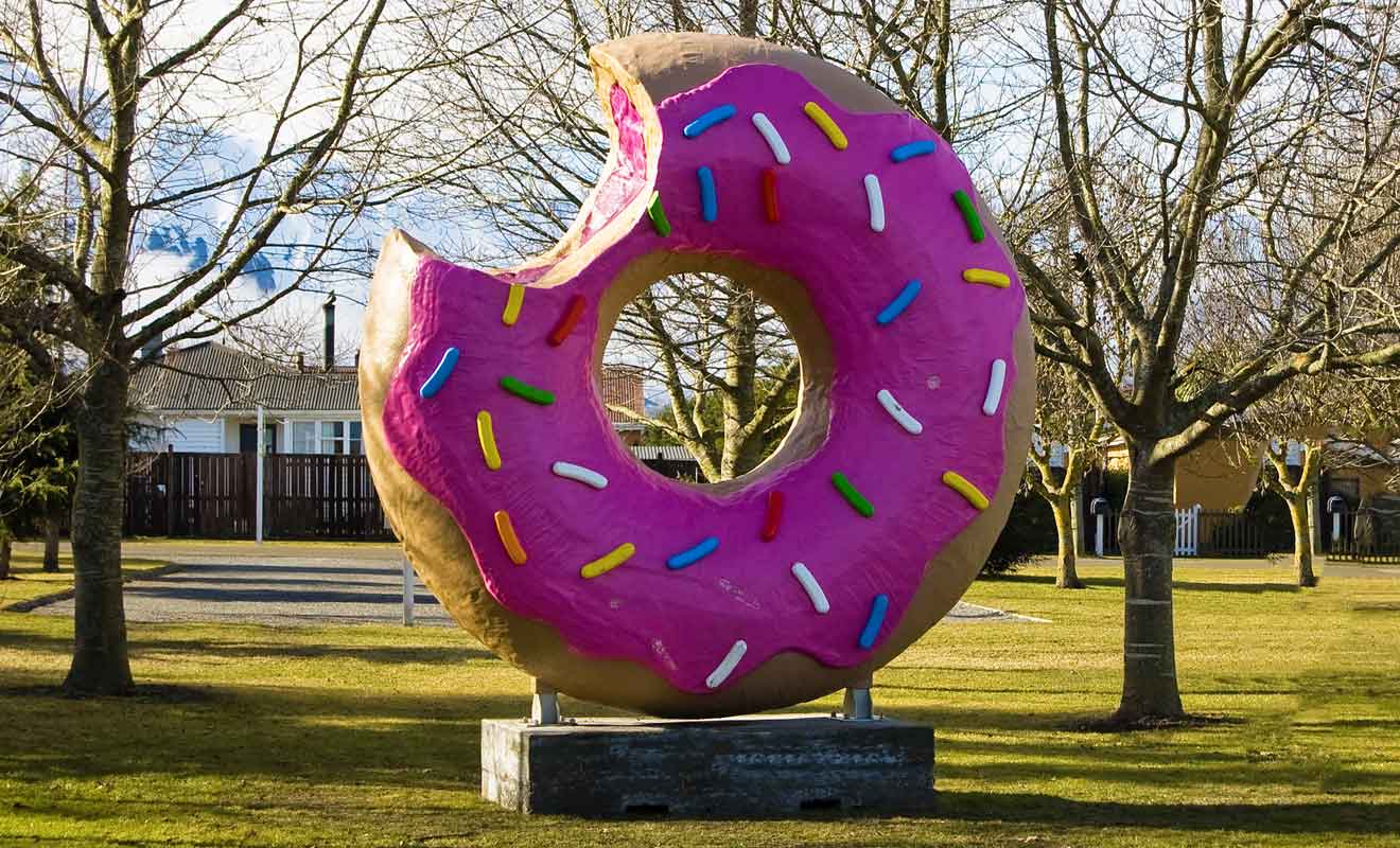 La première version du beignet géant fut incendiée puis remplacée par un simple pneu peint en rose avant qu'une statue définitive ne soit installée.