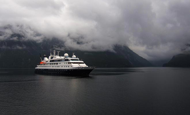 Kruisjes oversteken de wateren van het fjord met een paar zeilboten.