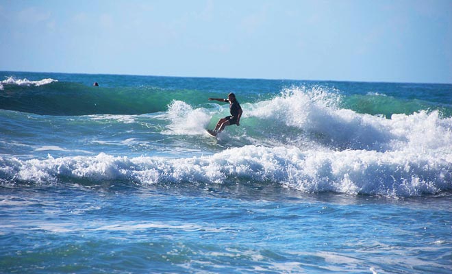 Hot Water Beach trekt surfers. Staar niet alleen met jaloers op hen en meld je aan om een ​​les te nemen.