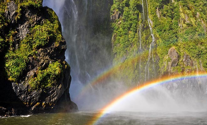 De honderden watervallen die ontstaan ​​door de regen worden door de wind geveegd. Vocht in de lucht onthult veel regenbogen.