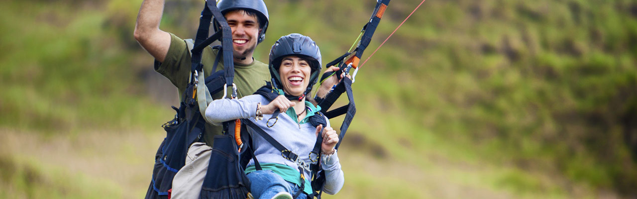 A couple enjoying paragliding in tandem in New Zealand.