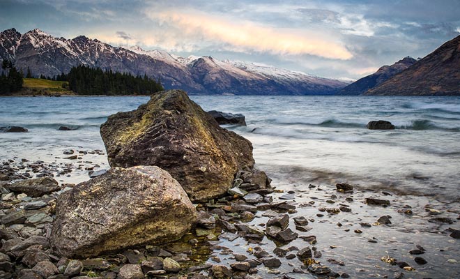 De toppen van de bergen rondom Lake Wakatipu zijn nog steeds in de vroege lente gesneeuwd.