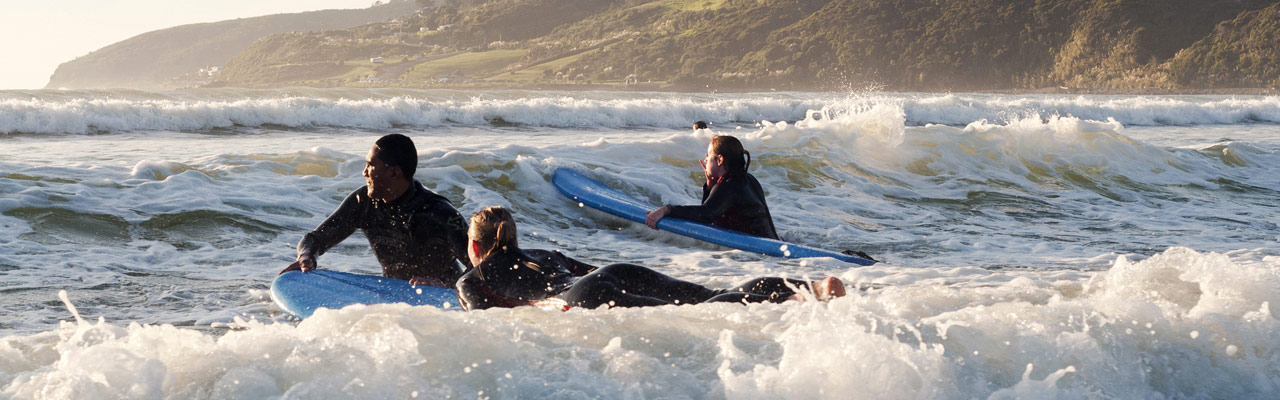 Jonge mensen nemen een surf les.